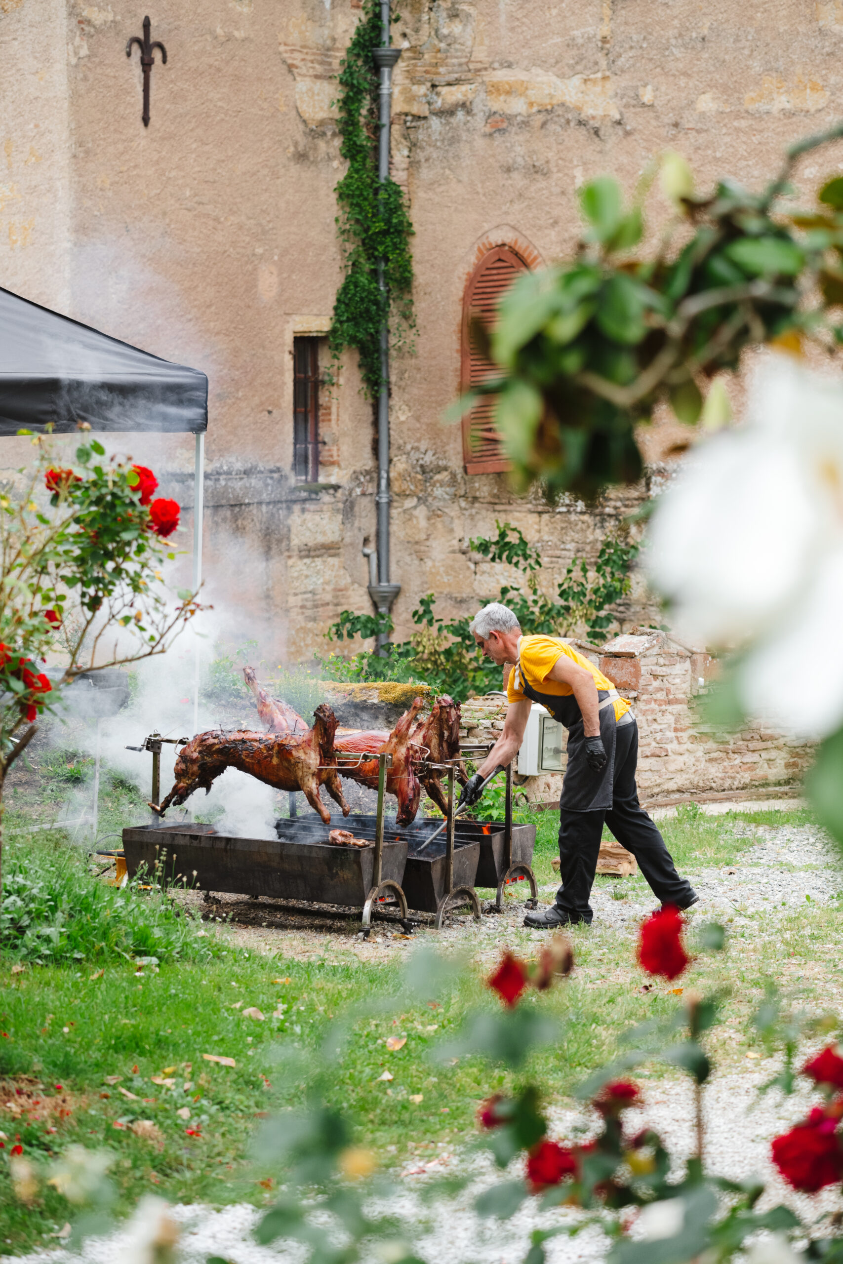 Chef surveillant la cuisson d’une pièce entière rôtie à la broche.